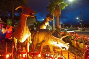 the dinosaur house at dusk with three large dinosaurs lit by soft lighting