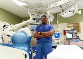 Maj. Fortune Egbulefu, Orthopedic surgeon and Chief of Surgery at Mike O'Callaghan Military Medical Center, stands in an operating room with robotics machines. Egbulefu has pioneered a hip and knee robotic surgery program at MOMMC, a new technology not widely available in the Las Vegas valley.