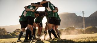 a rugby team huddles together before a game